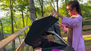 مادرخوانده سخت پیچانده شده در حالی که بیرون آشپزی می‌کند