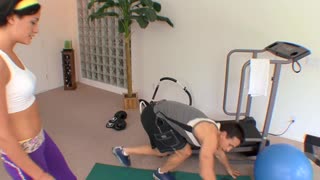 Mec musclé taquine et pilonne Eva Sinn près des équipements de gym