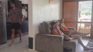 she's in the living room with her friend while he's in the kitchen