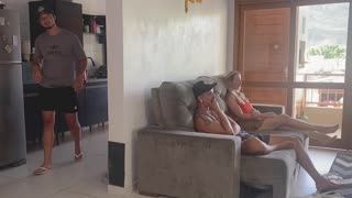 she's in the living room with her friend while he's in the kitchen