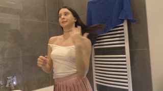 Braless Brunette Babe Shows Off Her Stunning Legs and Ass in a Pink Mini Skirt While in the Bathroom