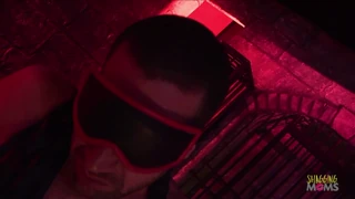 Inside the dimmed cell the blindfolded man awaits the blonde milf with big tits to start sucking