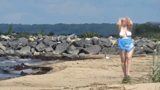 Hitze spüren: Kurvige Blonde im weißen Badeanzug am Strand